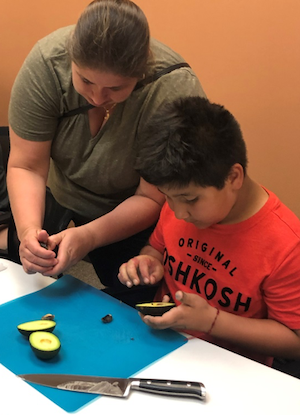 mom and son cutting avocado in cooking class
